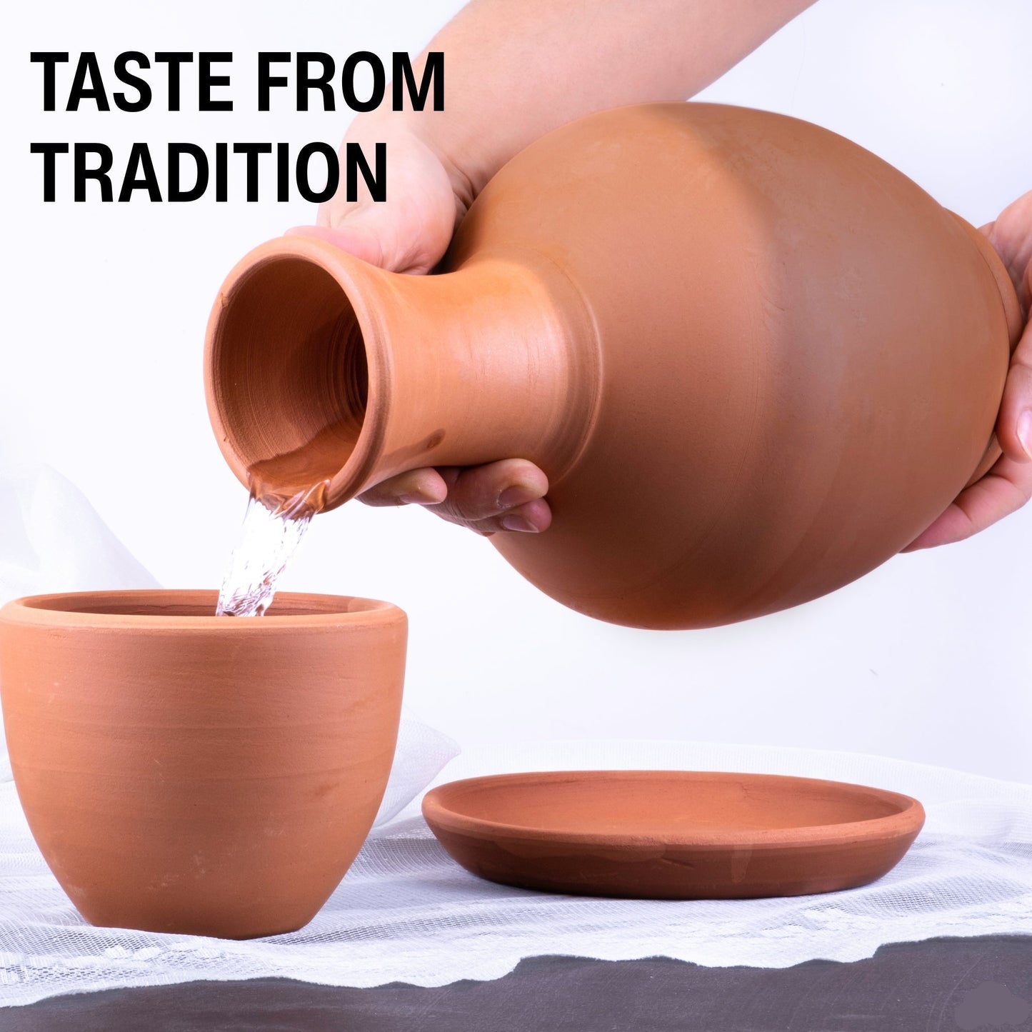 Person pouring water from a terracotta pot into another terracotta pot with a white background.