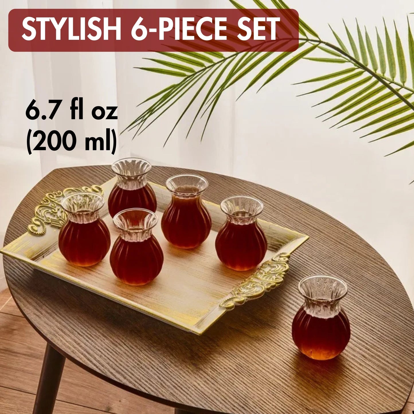 Stylish 6-piece glass set with tea on a wooden table, featuring a palm leaf decoration.