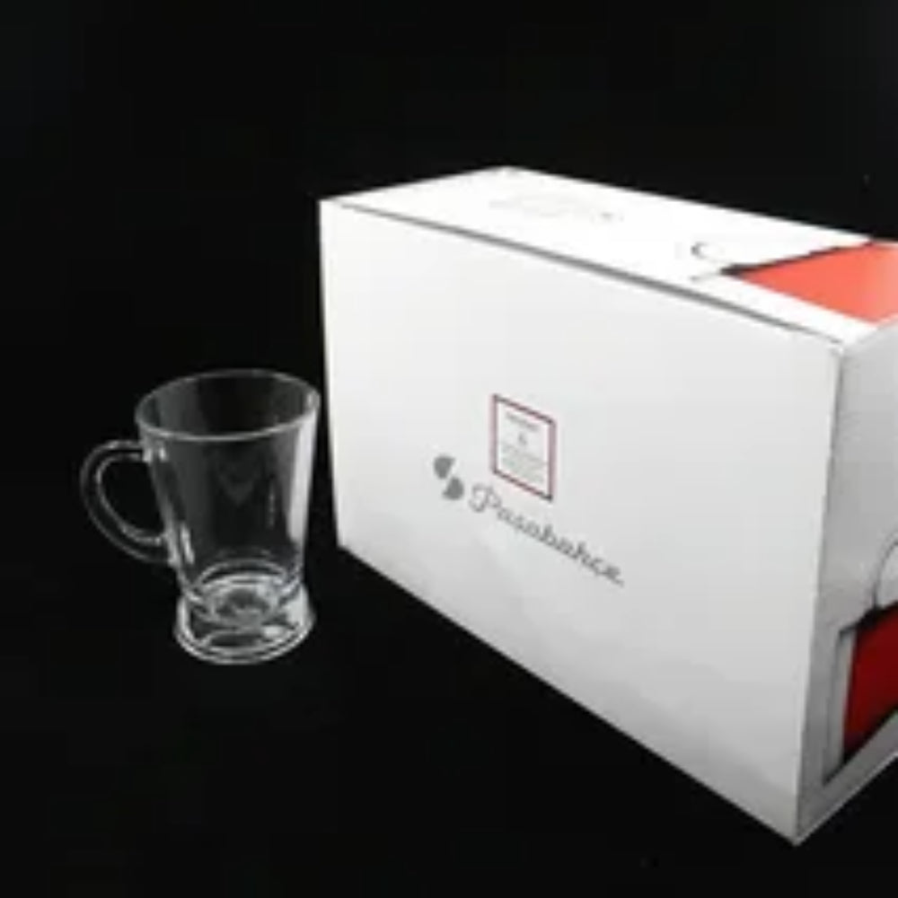 Clear glass mug in front of a white box with a brand logo on a black background