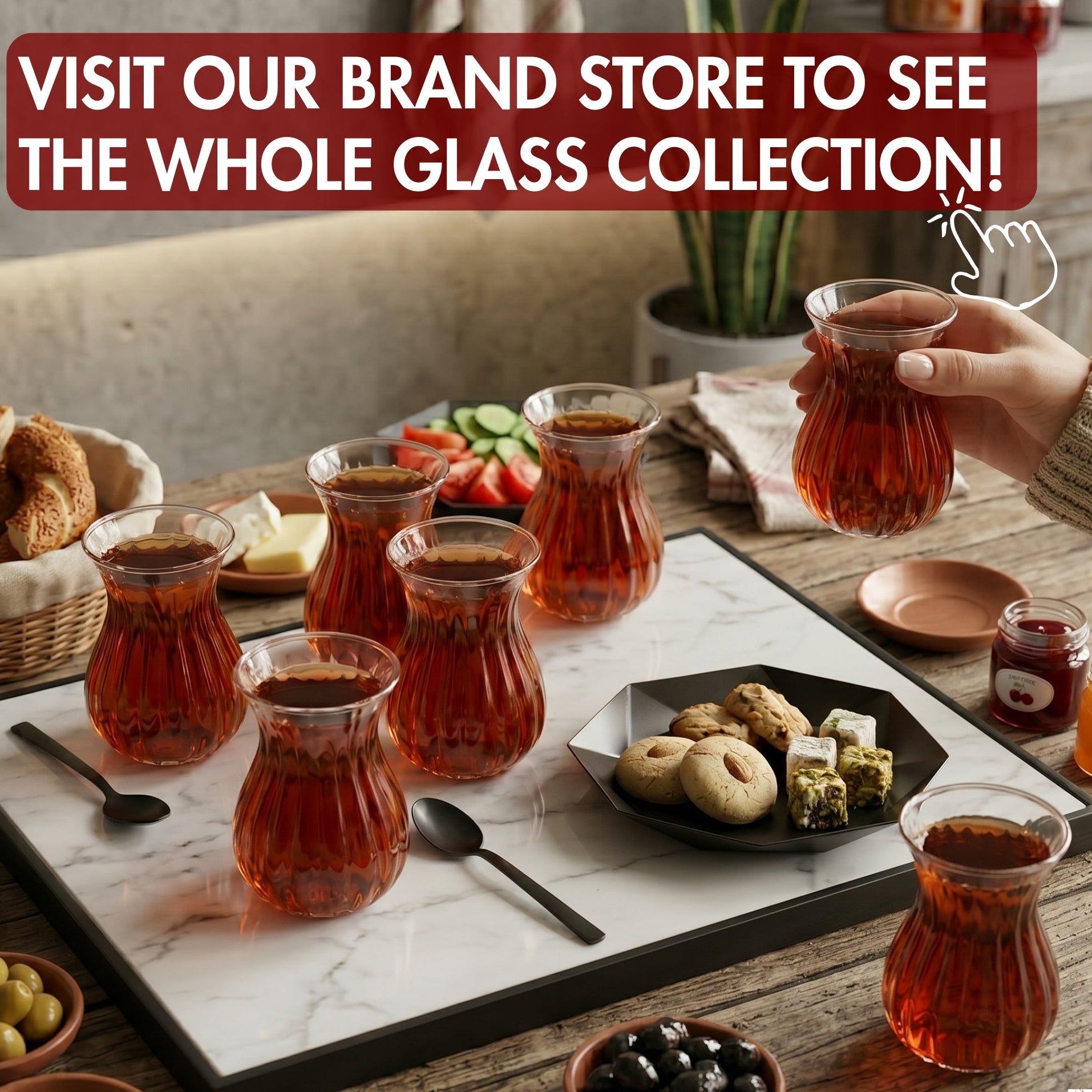 Table setting with glass cups filled with a dark liquid, accompanied by a hand holding one of the glasses. Text encourages visiting a brand store.