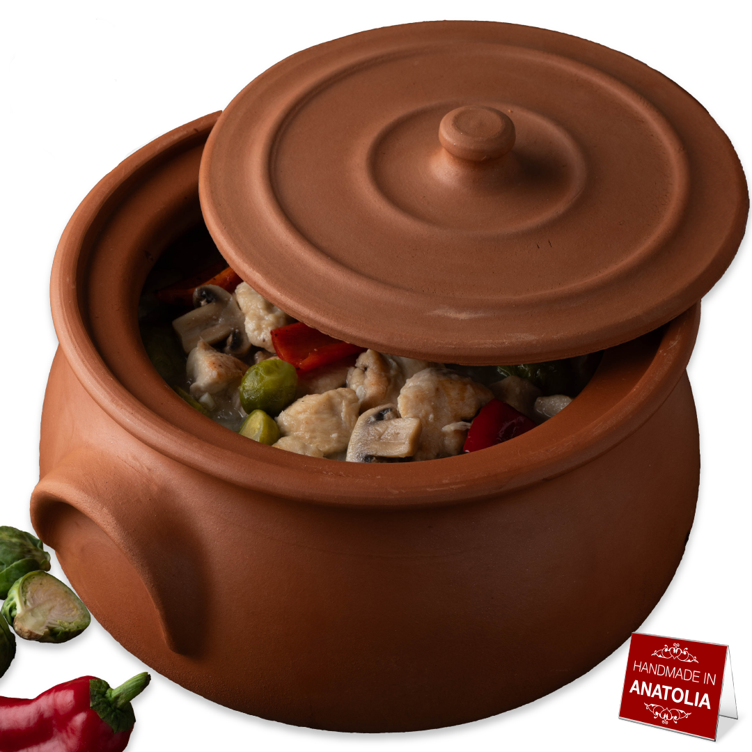Terracotta pot with food inside, surrounded by vegetables and a 'Made in Anatolia' label.