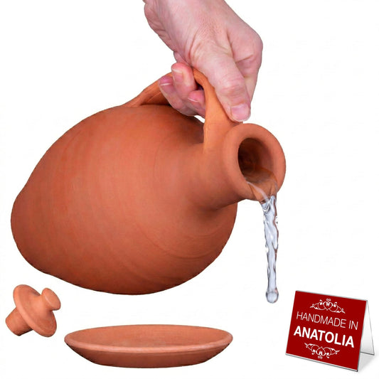 Terracotta pitcher being poured with packaging and additional terracotta items on a white background